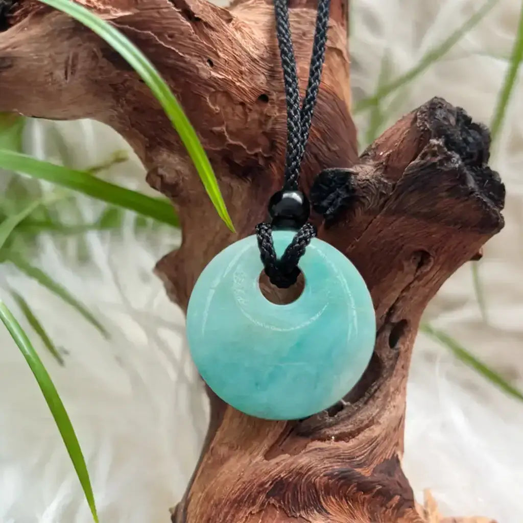 Nahaufnahme des runden Amazonit Anhängers als Heilstein Schmuck auf Naturholz – beruhigender Amazonit Schmuck für Harmonie & Balance.