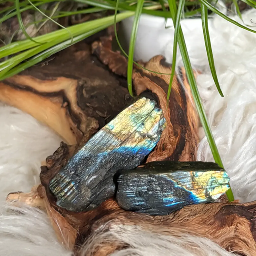 Detailansicht von zwei Labradorit Rohsteinen mit blau-goldenem Schimmer auf Holzuntergrund, ideal als Kraftsteine oder für spirituelle Anwendungen