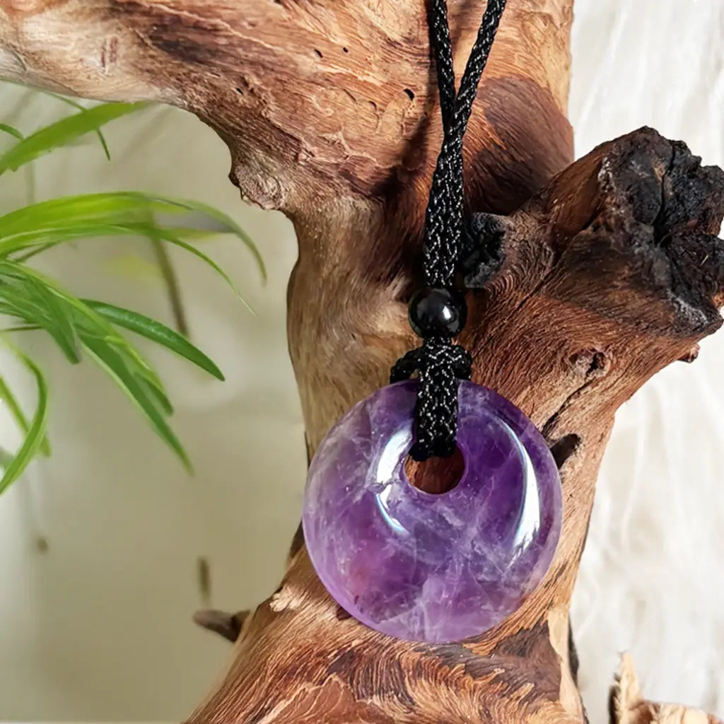 Nahaufnahme vom runden Amethyst Donut Anhänger mit schwarzem Band – energetischer Amazonit Schmuck für Klarheit, Schutz und Balance
