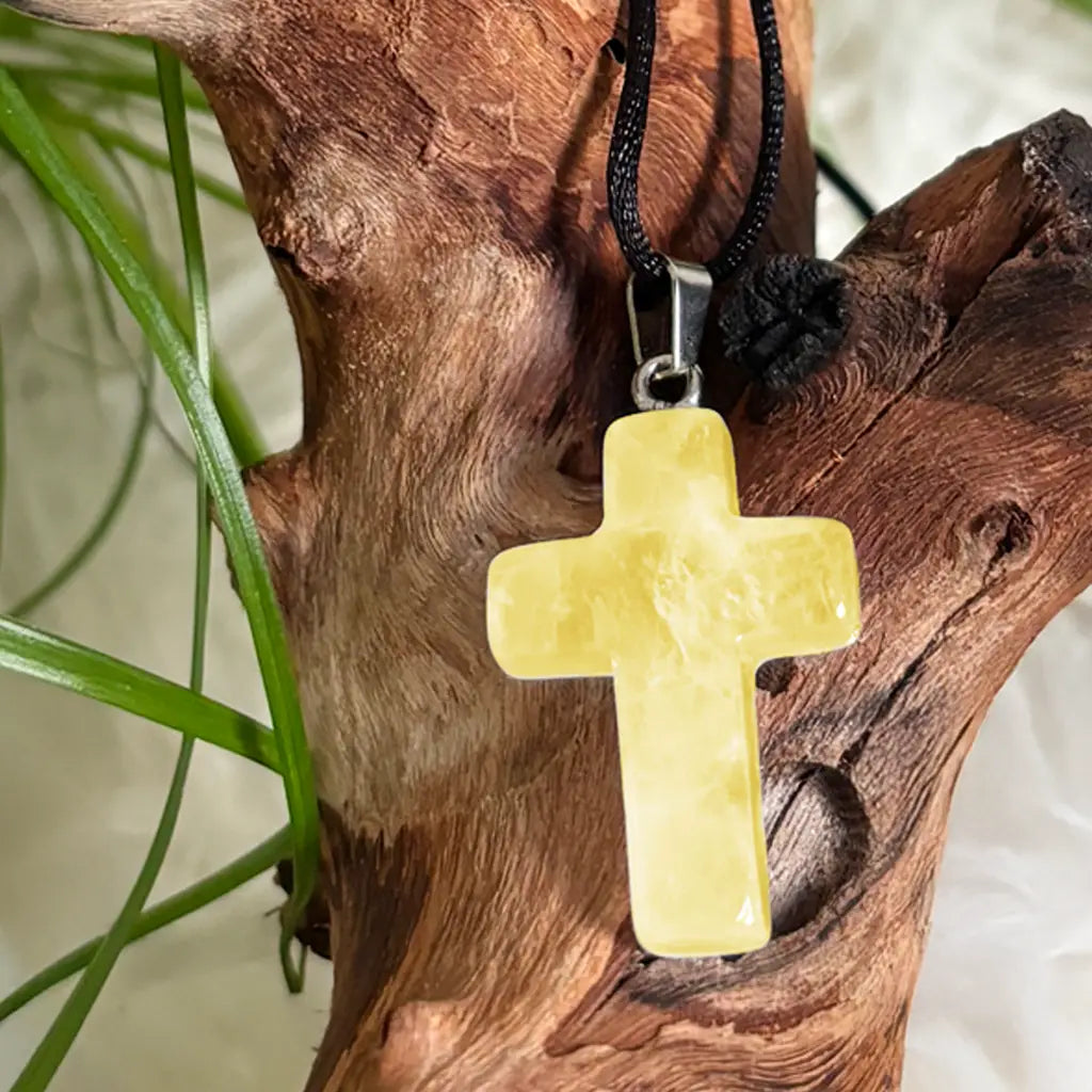 Nahaufnahme eines gelben Citrin Kreuz Anhängers mit Glanz auf Naturholz – stilvoller Edelsteinschmuck mit Bedeutung